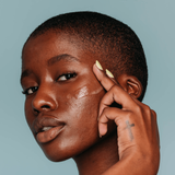 Model applied Own Your Tone Dark Spot Overnight Treatment to her cheek